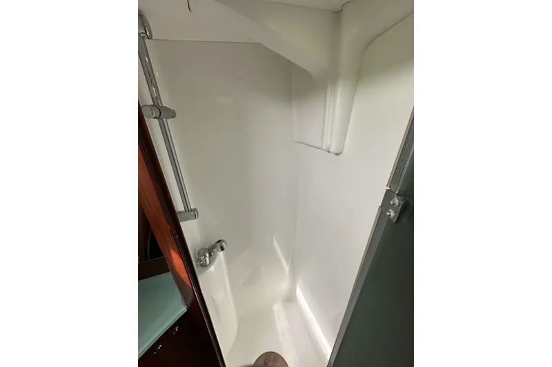 Slide: The Image of Shower area inside a 2003 Beneteau 57 yacht, featuring sleek white design. - 46