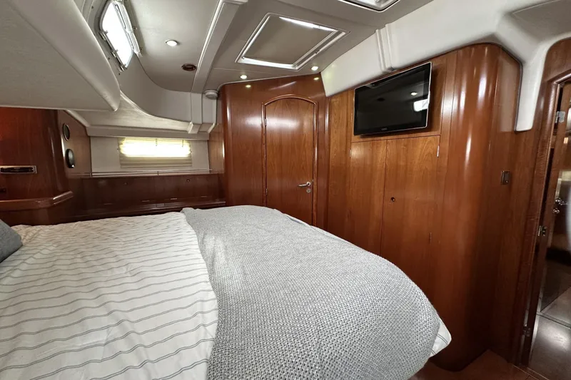 Slide: The Image of Luxurious cabin interior of a 2003 Beneteau 57 yacht with wood paneling and cozy bedding. - 47