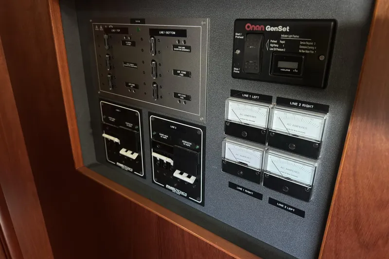 Slide: The Image of Electrical control panel on a 2003 Beneteau 57 yacht, featuring Onan GenSet and ammeters. - 61