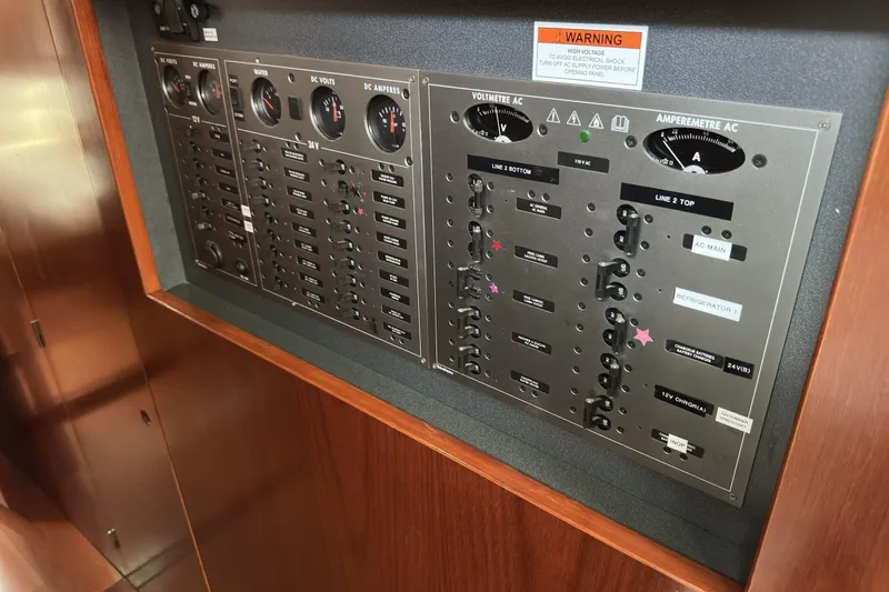 Slide: The Image of Electrical control panel on a 2003 Beneteau 57 yacht, featuring gauges and switches. - 62
