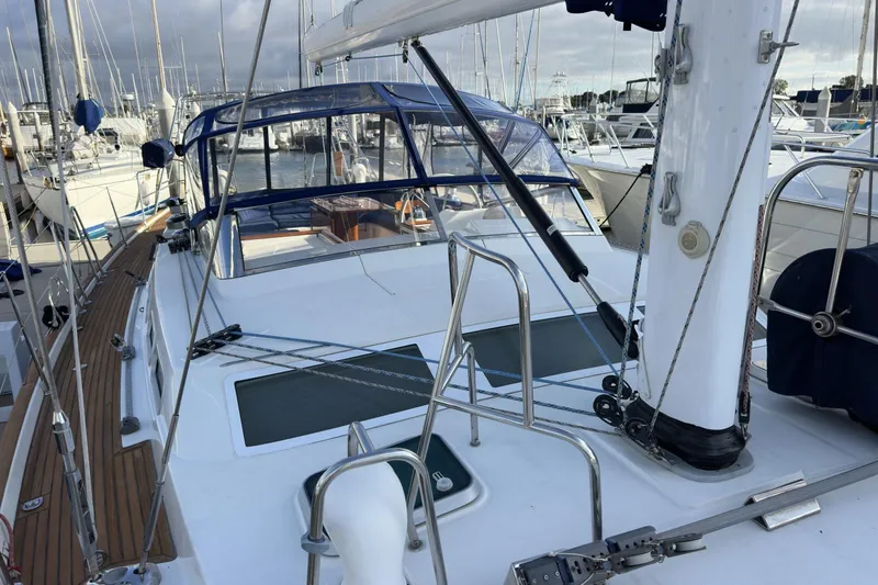 Slide: The Image of 2003 Beneteau 57 sailboat deck with rigging and marina background. - 75
