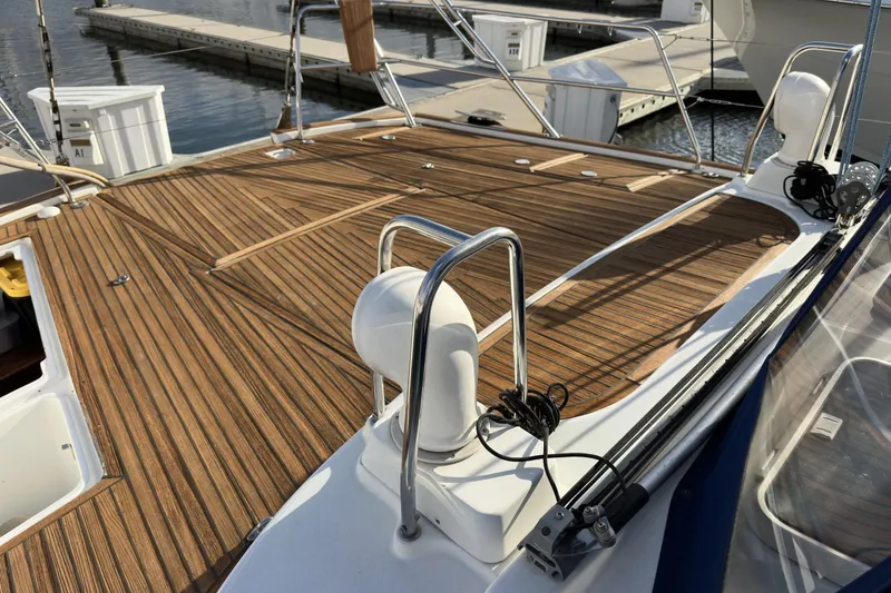 Slide: The Image of Deck of a 2003 Beneteau 57 yacht with teak wood finish at a marina. - 82