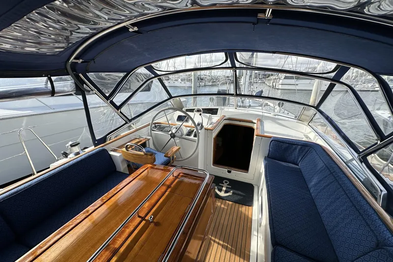 Slide: The Image of Luxurious 2003 Beneteau 57 yacht cockpit with elegant wood and blue seating. - 86
