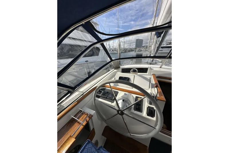 Slide: The Image of Helm of 2003 Beneteau 57 sailboat with marina view through windows. - 90