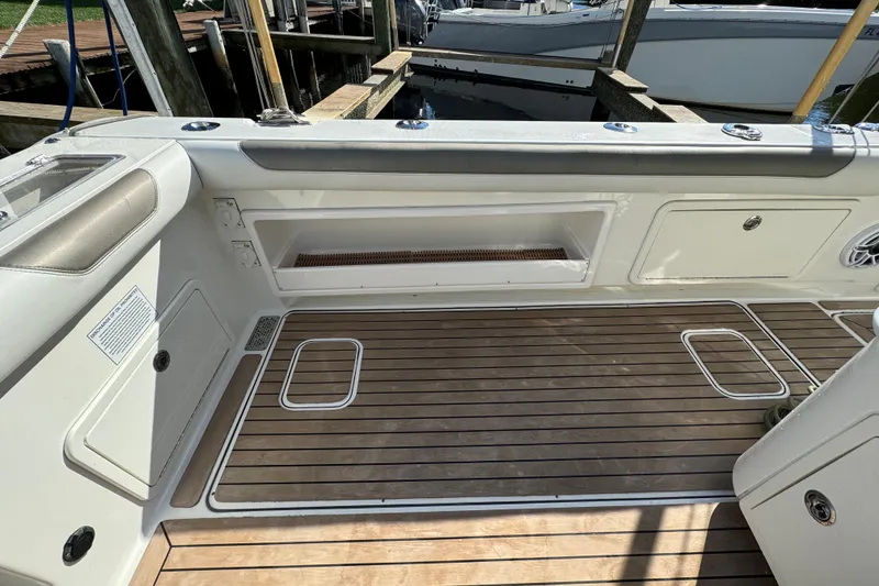 Slide: The Image of 2023 World Cat 325 CC boat interior with teak flooring and storage compartments. - 14