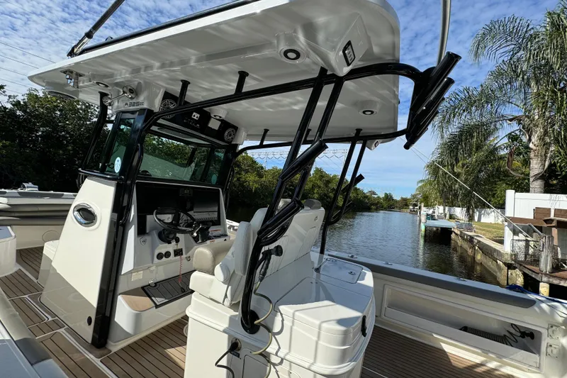 Slide: The Image of 2023 World Cat 325 CC boat interior with helm, docked by a scenic waterway. - 16