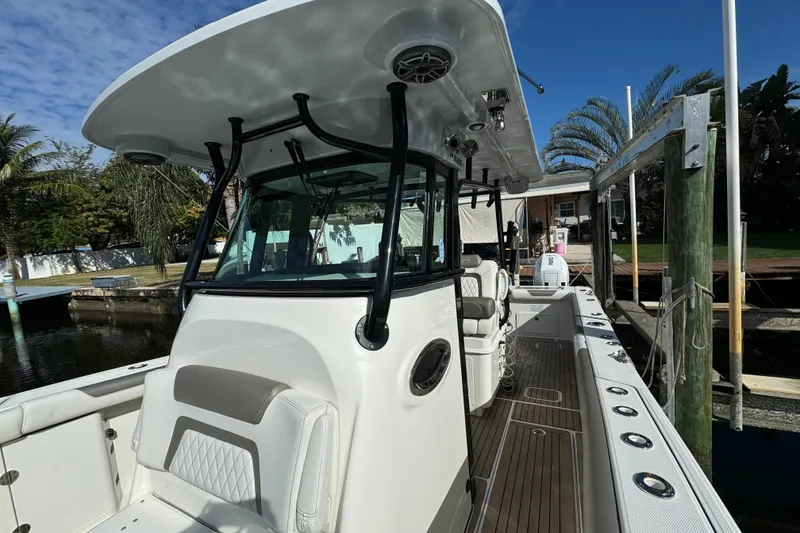 Slide: The Image of 2023 World Cat 325 CC boat docked, showcasing sleek design and spacious deck. - 18