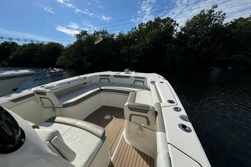 Slide: The Image of 2023 World Cat 325 CC boat interior with seating, on a sunny day by the water. - 21