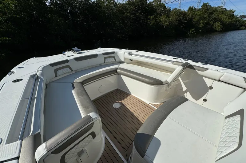 Slide: The Image of 2023 World Cat 325 CC boat interior with cushioned seating and wooden deck. - 22