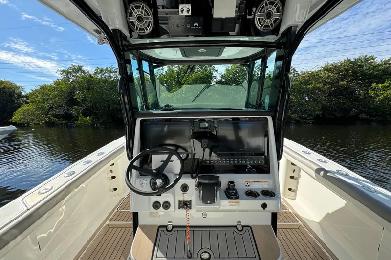 Slide: The Image of 2023 World Cat 325 CC boat cockpit with steering wheel and control panel. - 24
