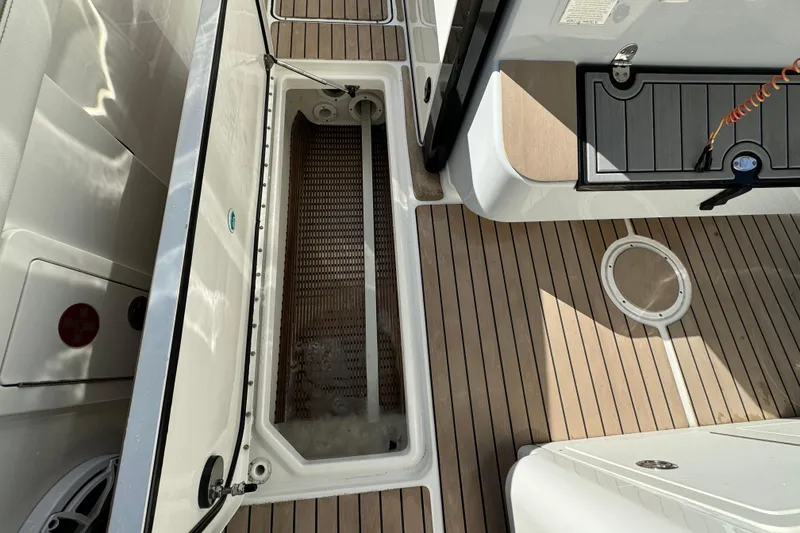 Slide: The Image of 2023 World Cat 325 CC boat deck with storage compartment and teak flooring. - 27