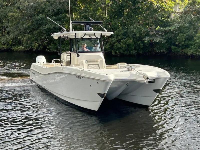 Slide: The Image of 2023 World Cat 325 CC boat cruising on a calm river. - 3