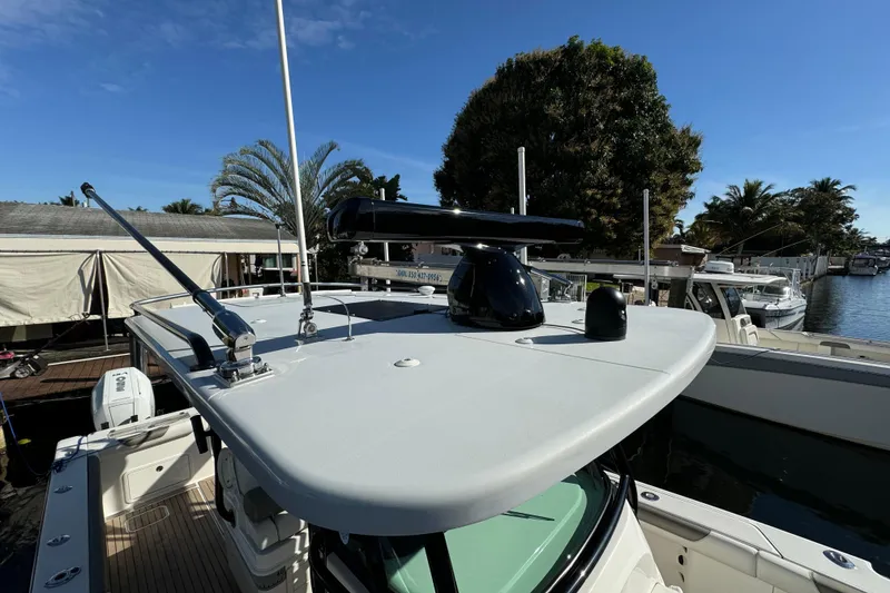 Slide: The Image of 2023 World Cat 325 CC boat roof with radar, docked near palm trees. - 31