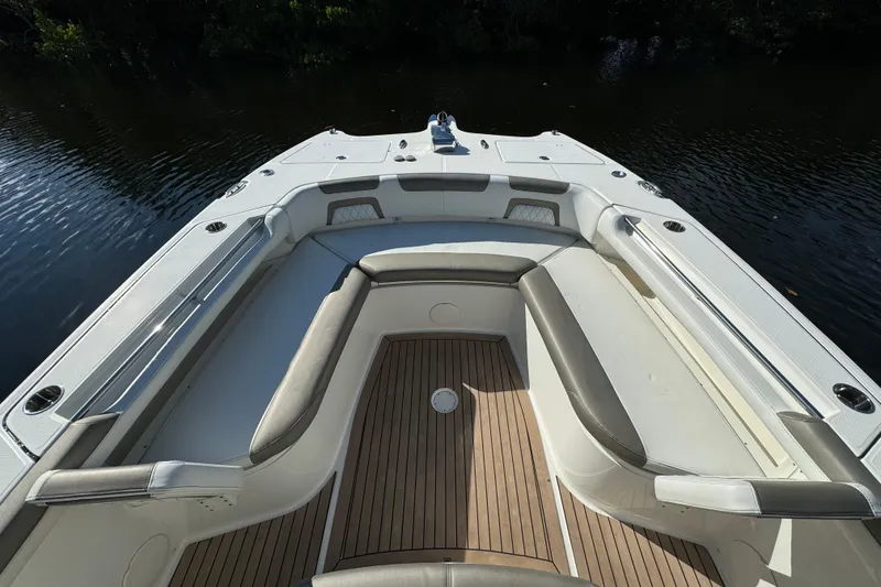Slide: The Image of 2023 World Cat 325 CC boat interior with cushioned seating and wooden deck. - 32