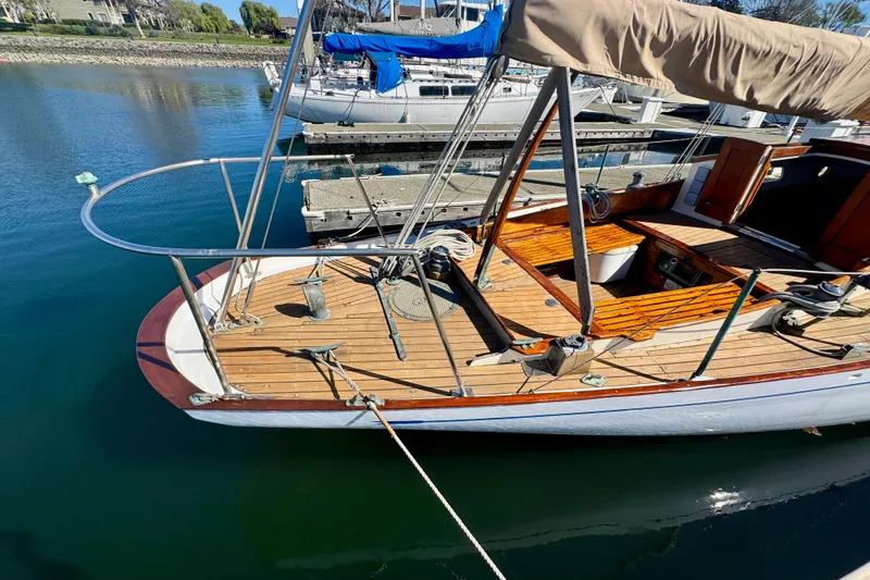Slide: The Image of Classic 1946 Phillip Rhodes 42 sailboat with wooden deck, docked in a serene marina. - 10