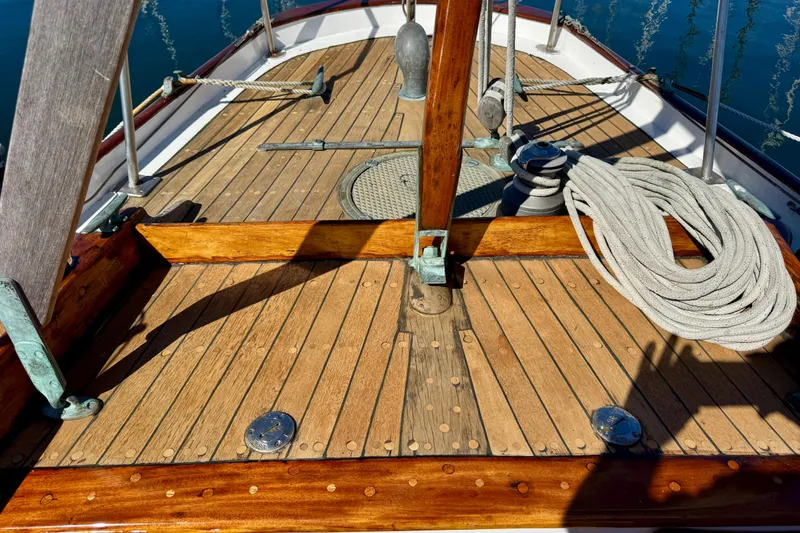 Slide: The Image of Wooden deck of a 1946 Phillip Rhodes 42 sailboat with coiled rope and fittings. - 12