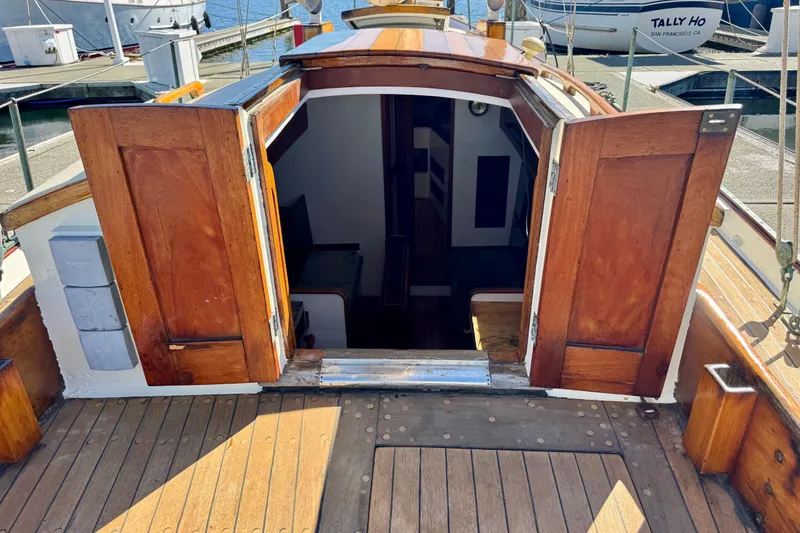 Slide: The Image of Wooden deck and open cabin doors of a 1946 Phillip Rhodes 42 sailboat. - 13