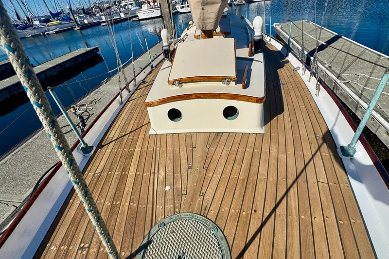 Slide: The Image of Vintage 1946 Phillip Rhodes 42 sailboat with wooden deck, docked at a marina. - 16