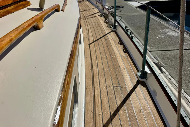 Slide: The Image of Wooden deck of a 1946 Phillip Rhodes 42 sailboat, showcasing polished wood and railings. - 19