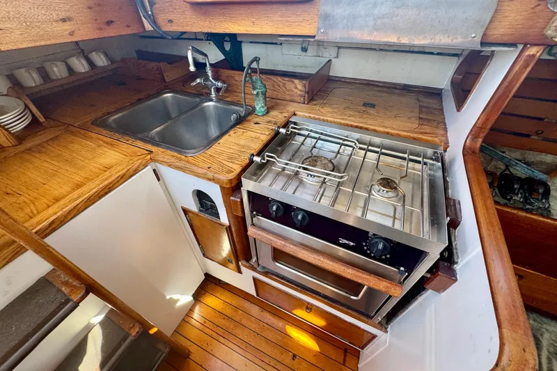 Slide: The Image of Vintage 1946 Phillip Rhodes 42 yacht kitchen with wooden cabinetry and stainless steel stove. - 23