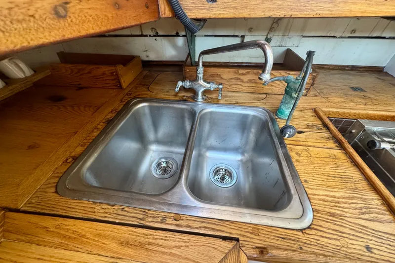 Slide: The Image of Vintage 1946 Phillip Rhodes 42 yacht kitchen with dual stainless steel sink and wooden countertop. - 26