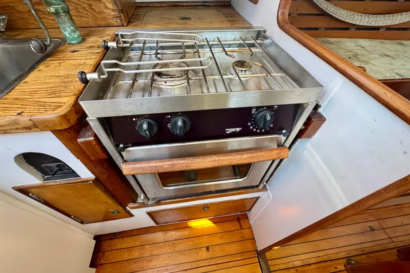 Slide: The Image of Vintage 1946 Phillip Rhodes 42 yacht kitchen with stove and wooden cabinetry. - 27