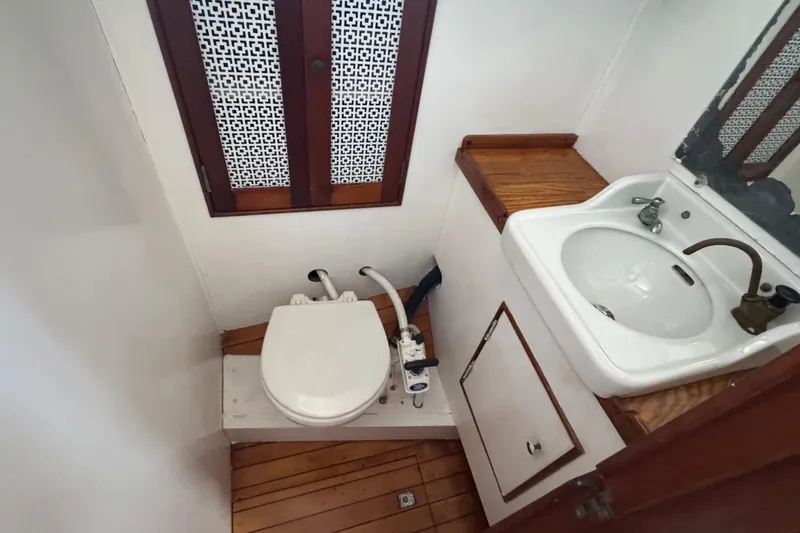 Slide: The Image of Vintage 1946 Phillip Rhodes 42 yacht bathroom with wooden accents, sink, and toilet. - 29