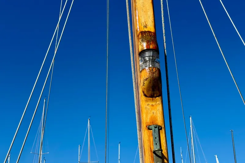Slide: The Image of Wooden mast of a 1946 Phillip Rhodes 42 sailboat against a clear blue sky. - 31