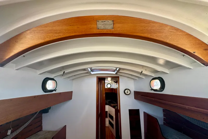 Slide: The Image of Interior of a 1946 Phillip Rhodes 42 sailboat, featuring wooden beams and portholes. - 36