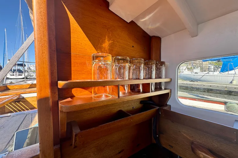 Slide: The Image of Wooden interior of a 1946 Phillip Rhodes 42 boat with glassware on shelves. - 43