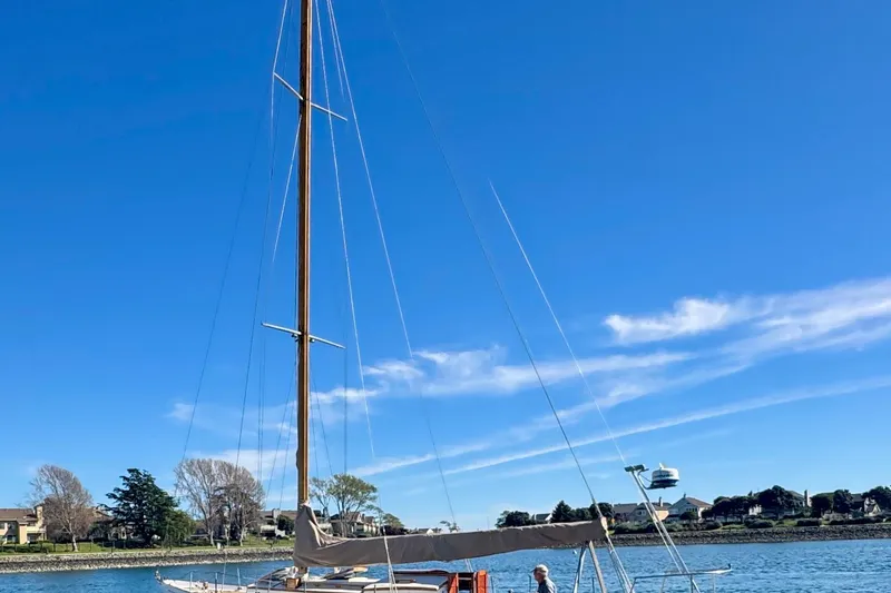 Slide: The Image of Sailboat on calm water, Phillip Rhodes 42, 1946 model, under clear blue sky. - 6