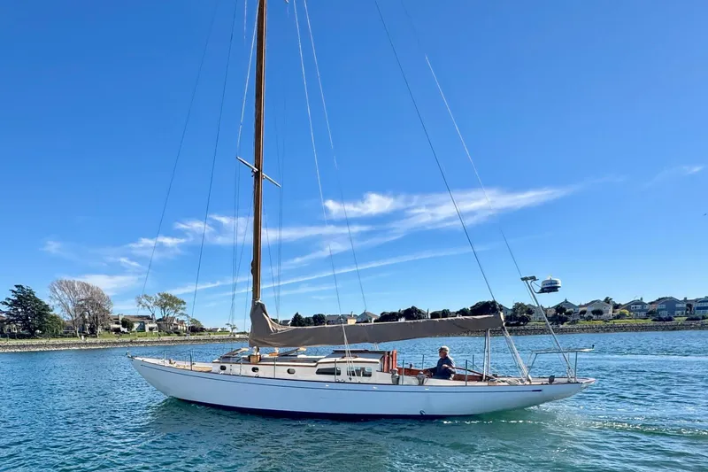 Slide: The Image of Vintage 1946 Phillip Rhodes 42 sailboat on calm water under clear blue sky. - 7