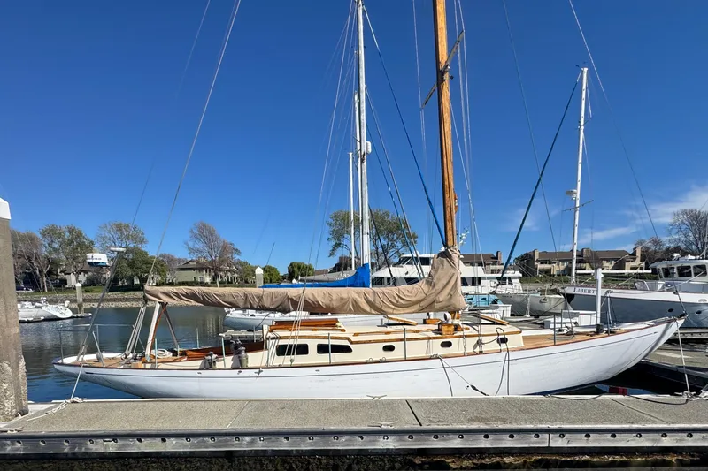 Slide: The Image of Classic 1946 Phillip Rhodes 42 sailboat docked in a marina under clear blue skies. - 8