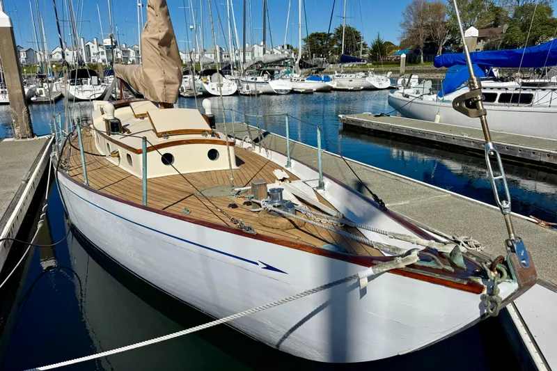 Slide: The Image of Vintage 1946 Phillip Rhodes 42 sailboat docked in a marina, showcasing classic wooden design. - 9