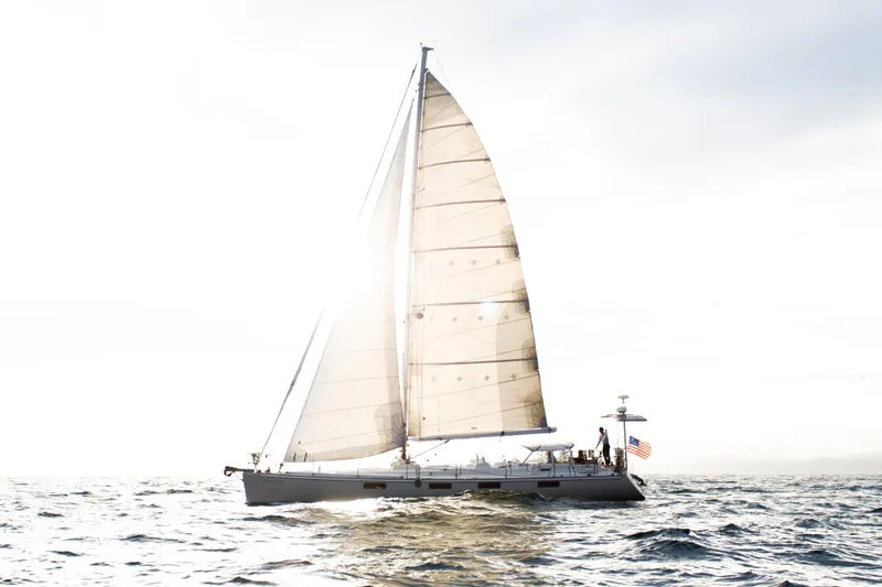 Slide: The Image of Sundeer 56 sailboat from 1995 sailing on open water with sunlight filtering through sails. - 10