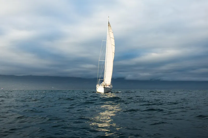Slide: The Image of Sundeer 56 sailboat from 1995 navigating open sea under cloudy skies. - 11