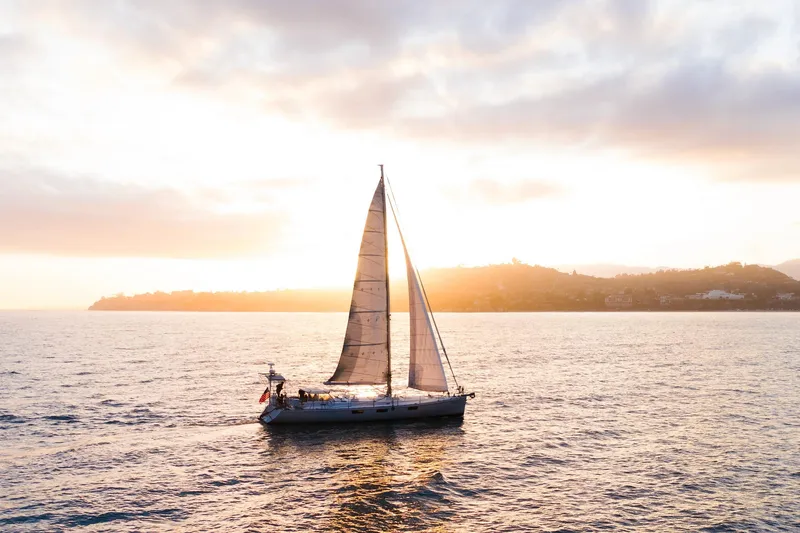 Slide: The Image of Sundeer 56 sailboat from 1995 sailing at sunset on open water. - 15