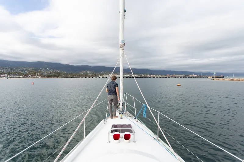Slide: The Image of Sundeer 56 sailboat from 1995 on calm waters with scenic coastal view. - 16