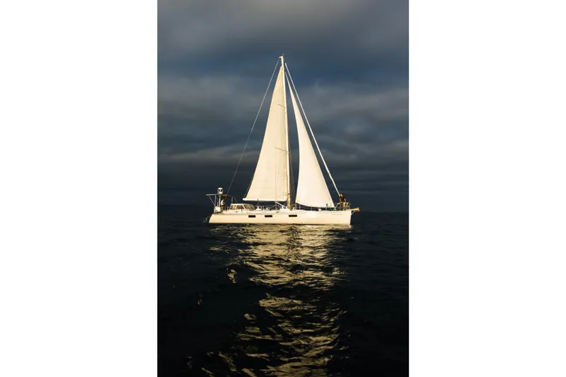 Slide: The Image of Sundeer 56 sailboat from 1995 on calm waters under dramatic sky. - 2