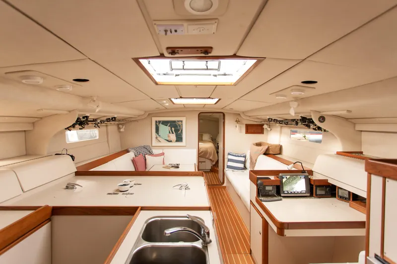Slide: The Image of Interior of a 1995 Sundeer 56 yacht, featuring a cozy, well-lit cabin space. - 25