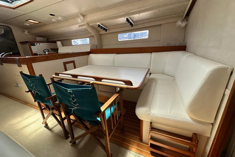 Slide: The Image of Cozy 1995 Sundeer 56 yacht interior with white seating and wooden accents. - 32