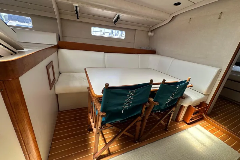 Slide: The Image of Interior of a 1995 Sundeer 56 yacht with a cozy dining area and wooden flooring. - 33