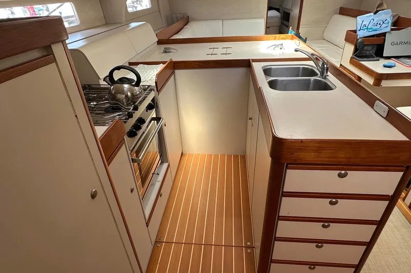 Slide: The Image of 1995 Sundeer 56 yacht kitchen with stove, sink, and wooden cabinetry. - 46