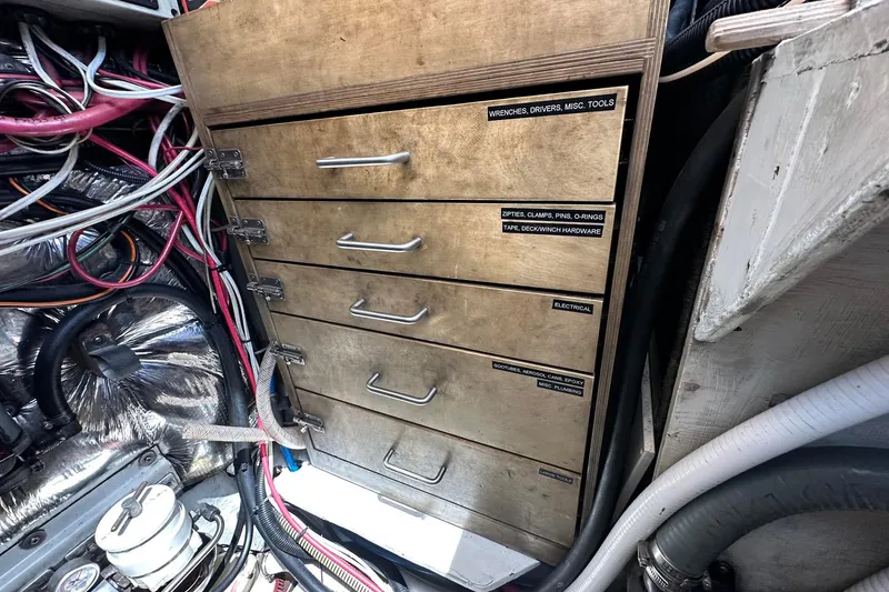 Slide: The Image of Wooden storage drawers labeled for tools and hardware, surrounded by colorful cables. Sundeer 56, 1995. - 56