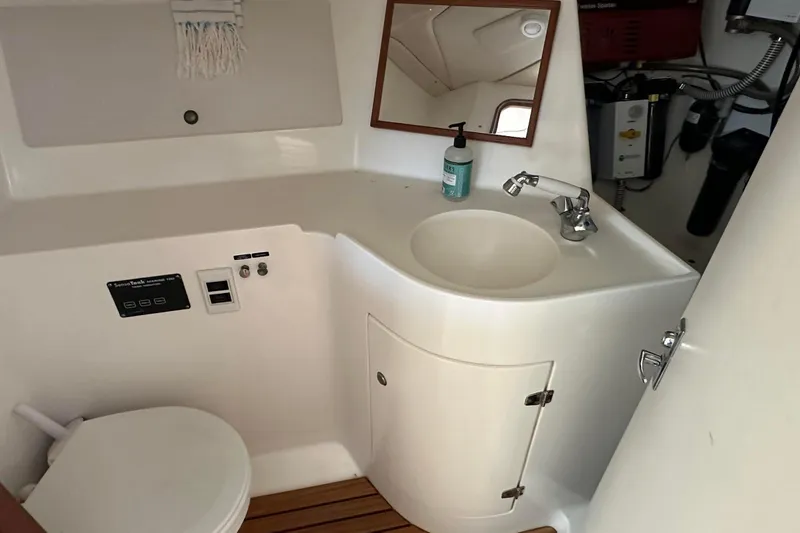Slide: The Image of Compact boat bathroom with sink, toilet, and mirror in a 1995 Sundeer 56 model. - 57