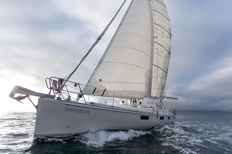 Slide: The Image of Sundeer 56 sailboat from 1995 navigating ocean waves under cloudy skies. - 8