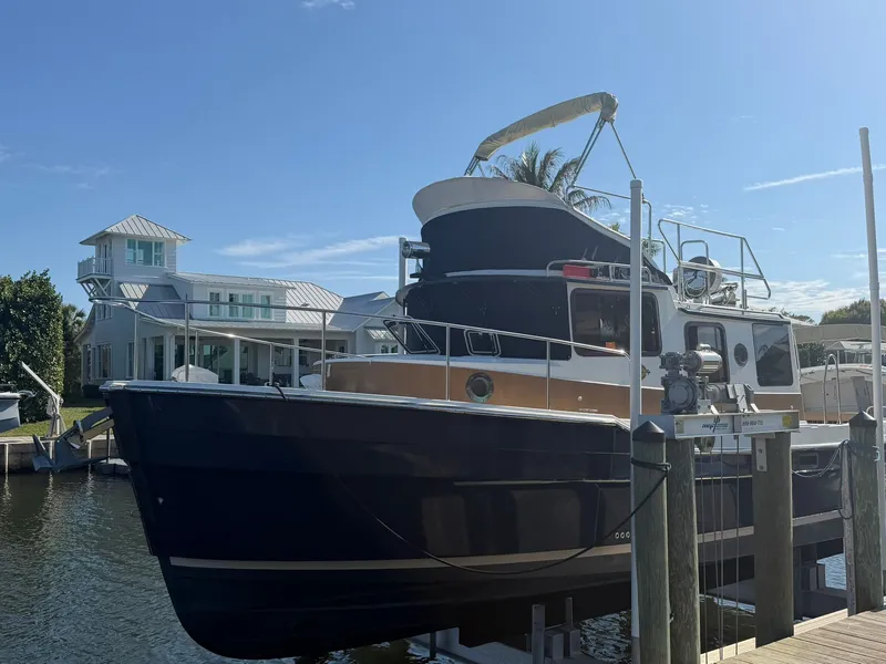 The Image of 2013 Ranger Tugs R-31 CB on a boat lift in front of a modern house. - 0
