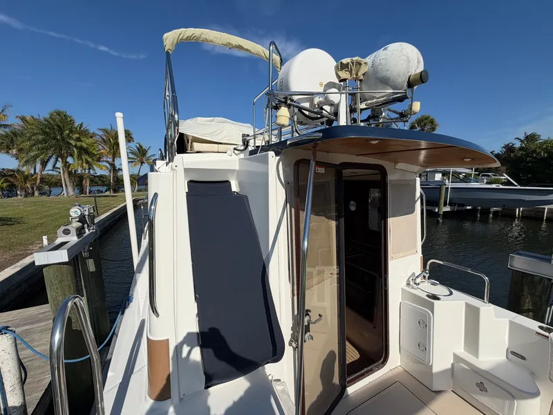 Slide: The Image of 2013 Ranger Tugs R-31 CB docked with palm trees in the background. - 14