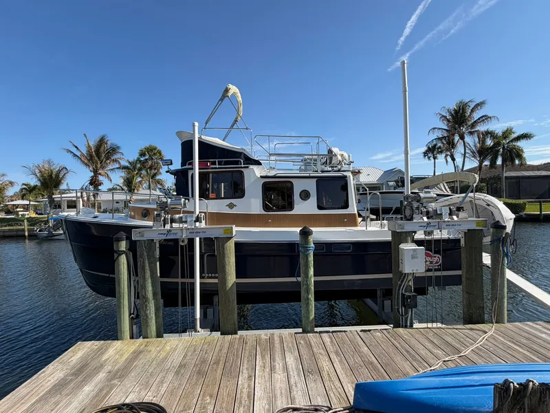 Slide: The Image of 2013 Ranger Tugs R-31 CB boat docked with palm trees. - 2