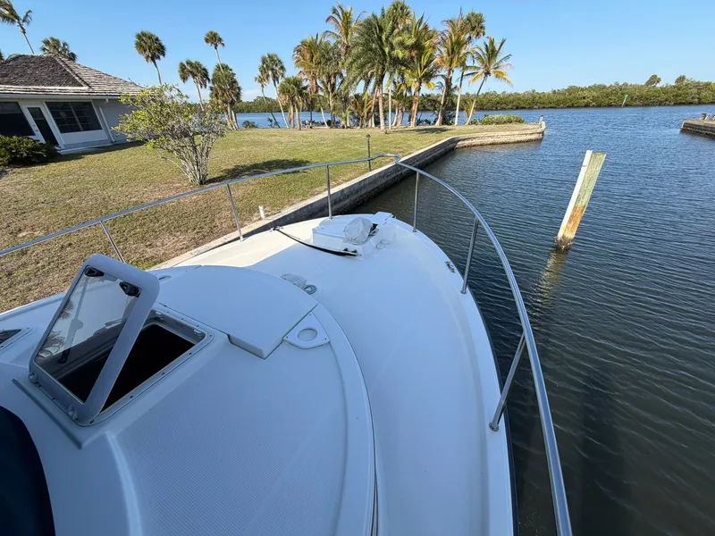 Slide: The Image of 2013 Ranger Tugs R-31 CB boat by the water with palm trees in background. - 21
